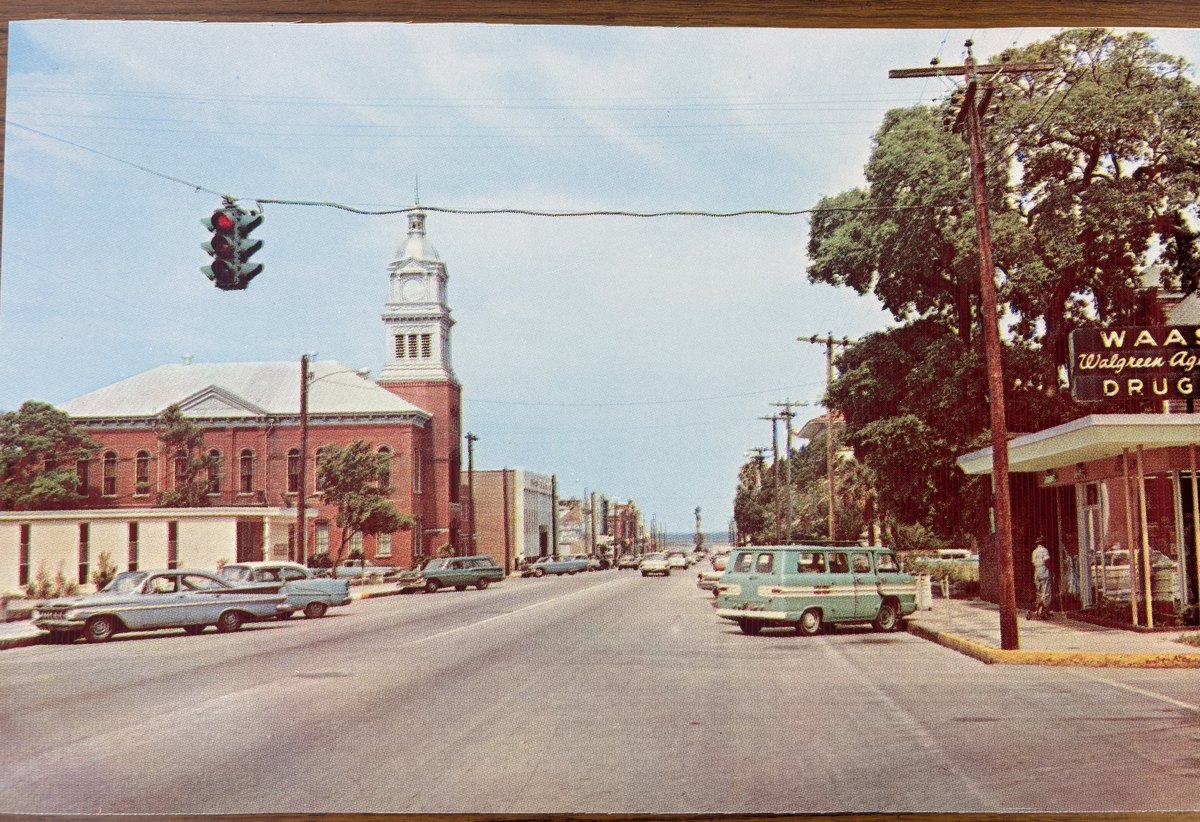 Centre Street in the early 1960s, the Waas Drugs neon sign at right and the Nassau County courthouse clock tower beyond